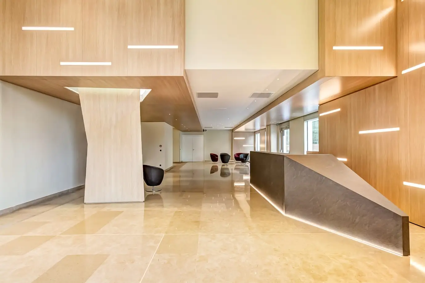 Bright reception area with wood panelling, stone floor and a long front desk