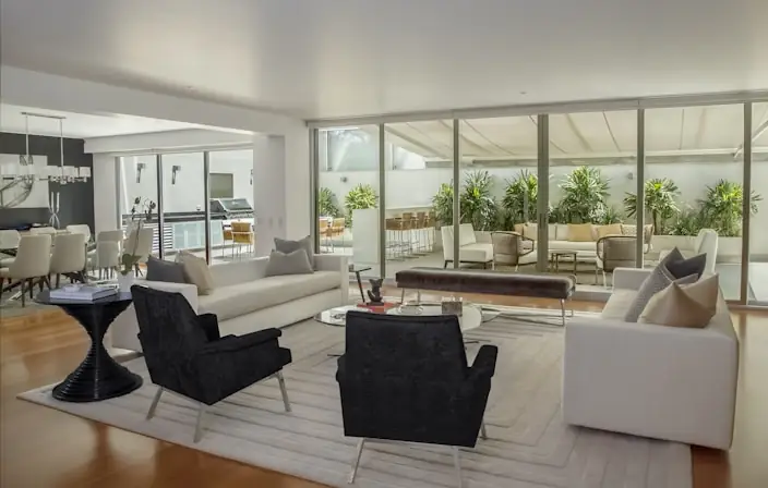 Formal living room opening through glass walls to a courtyard
