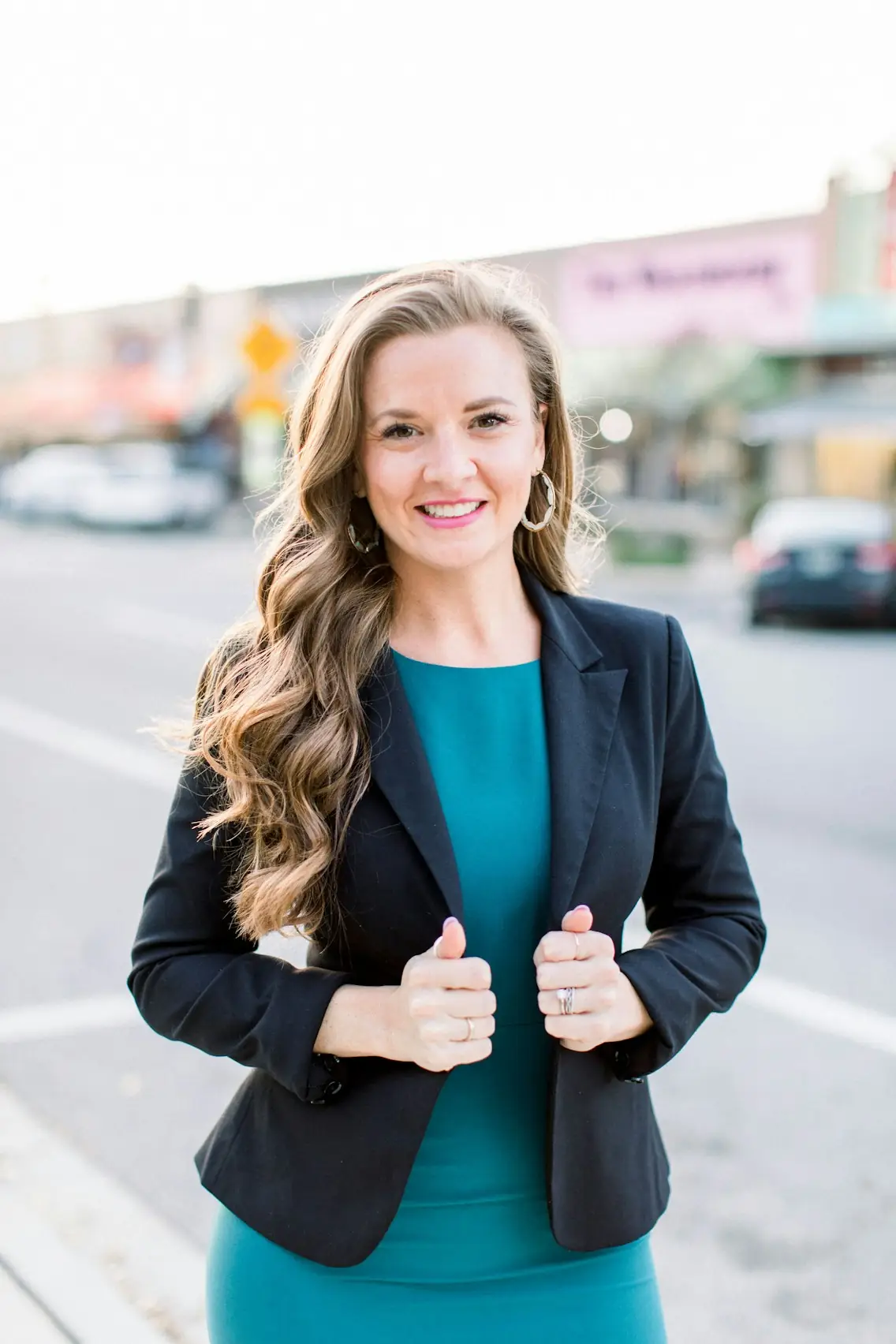 Broker standing on a small-town main street in a dark blazer