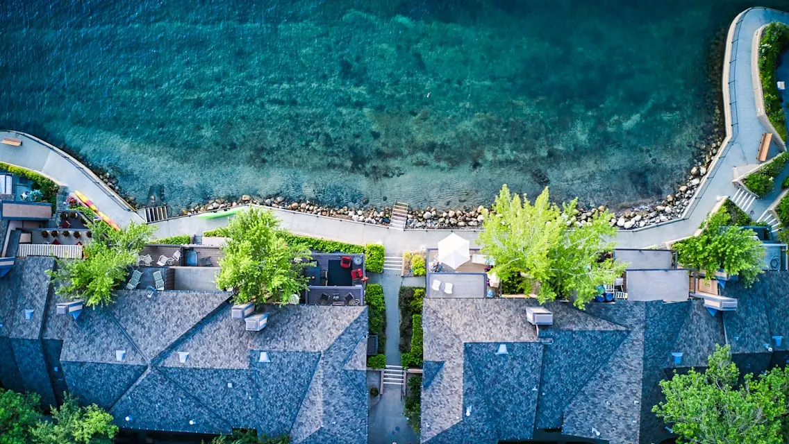 Aerial view of lakeshore homes along a curving waterside road